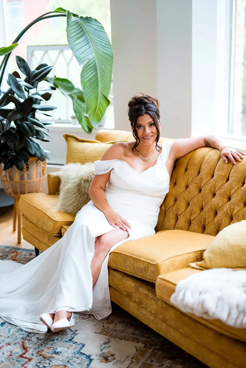 Bride relaxing on the gold velvet sofa before the ceremony