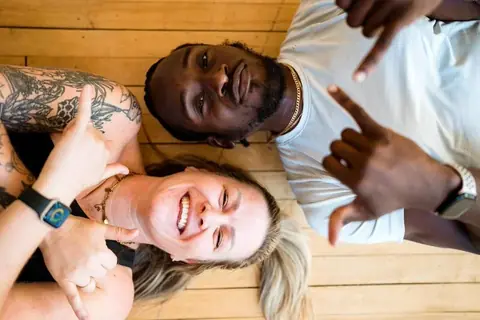 Friends laughing on the hardwood floor during a party