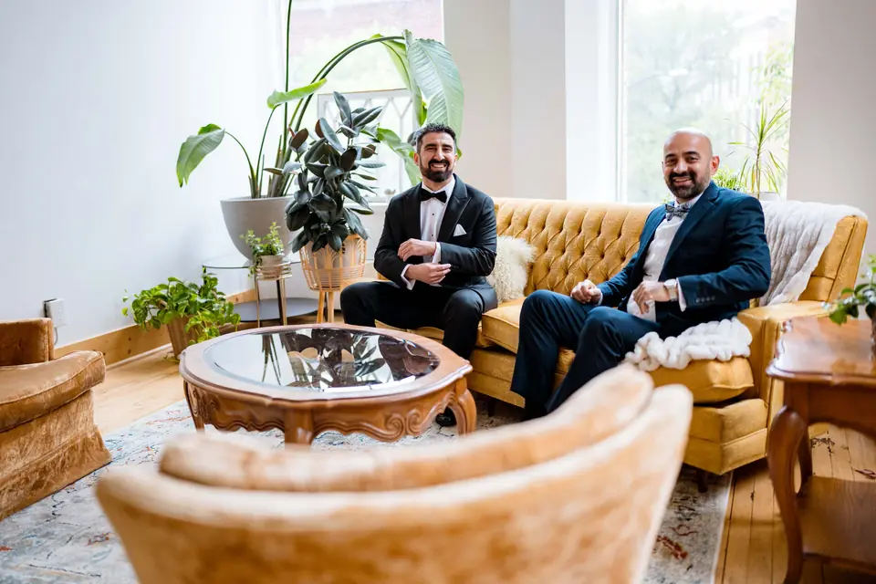 Groom and groomsman relaxing on the velvet lounge set