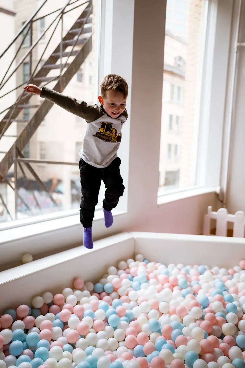 Child jumping into a ball pit during a birthday party