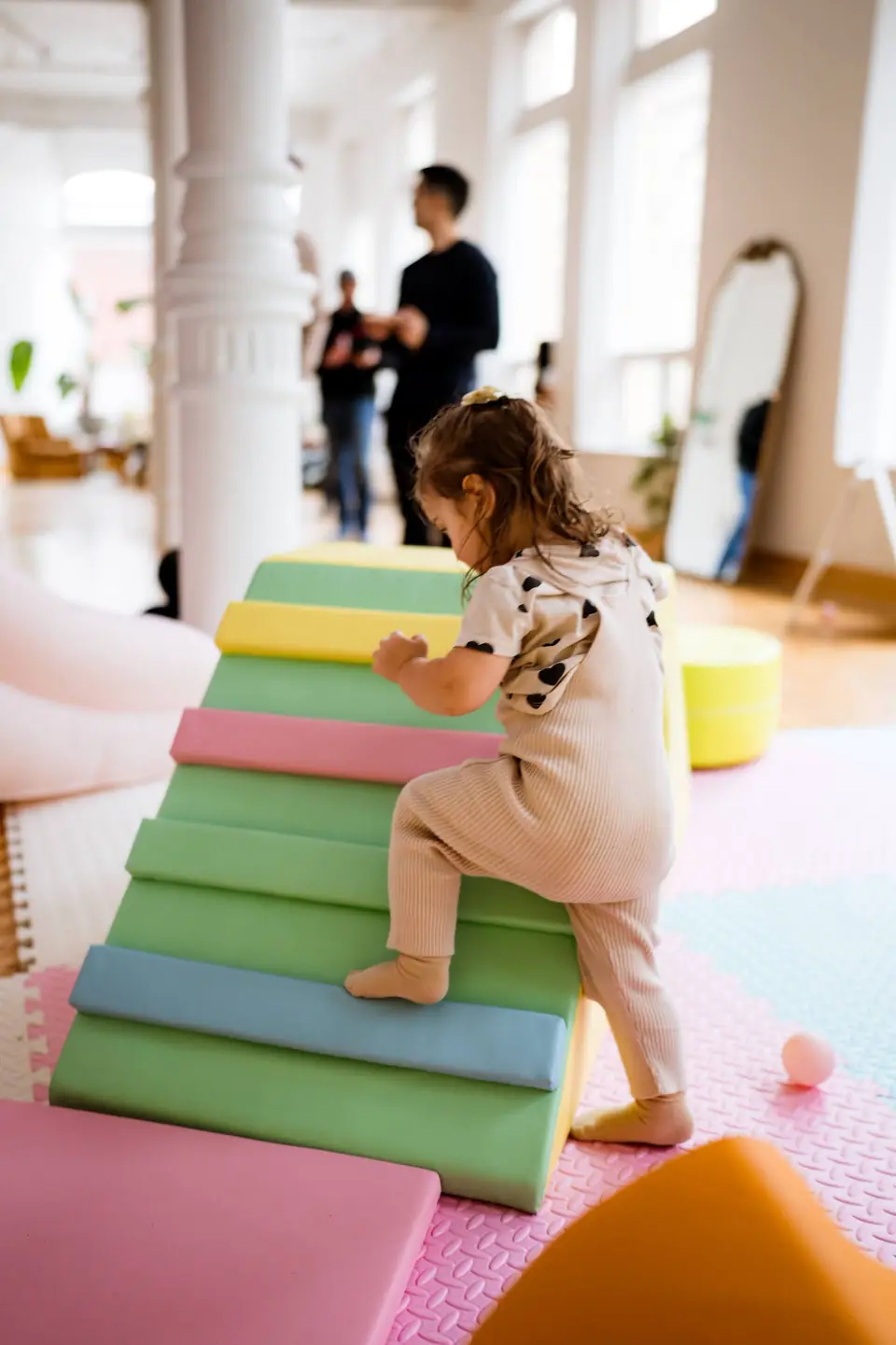 Toddler climbing soft play blocks at a family party
