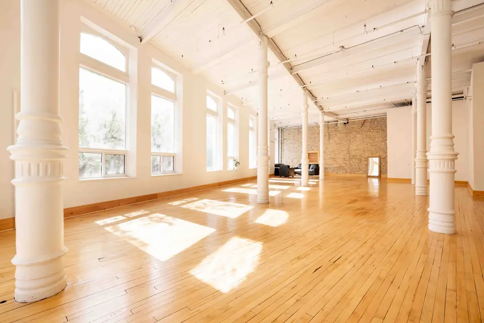 Open hardwood floor and white columns in the main hall, ready for setup