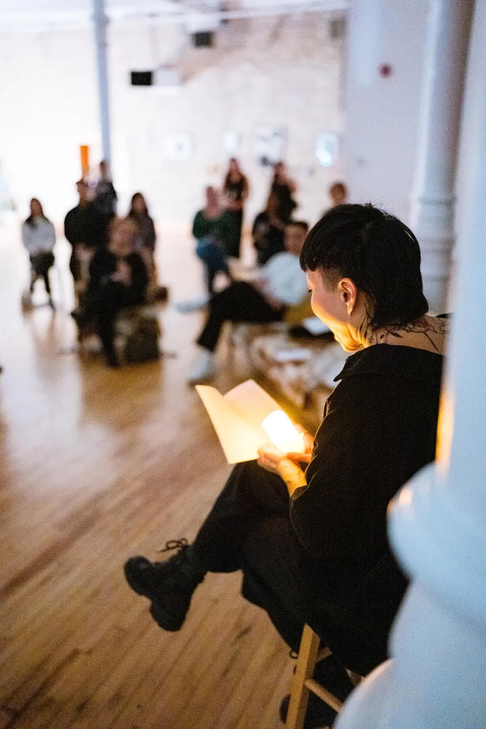 Guest reading by lamplight during an evening literary event