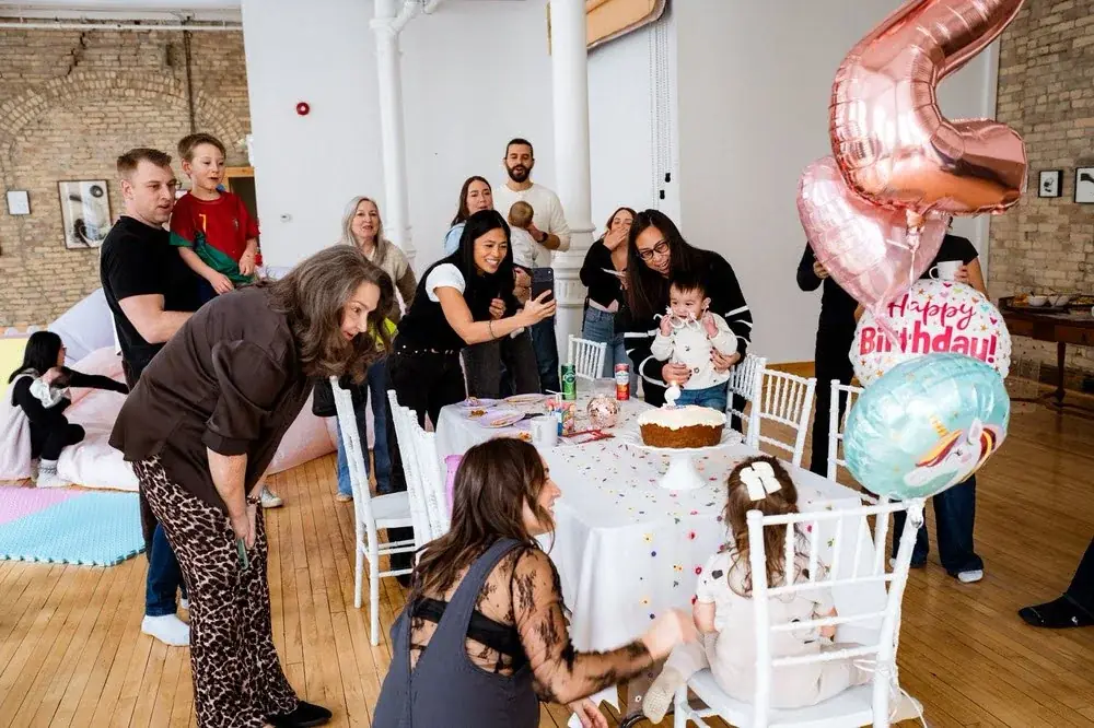 Family and friends gathered around a birthday table in the main hall