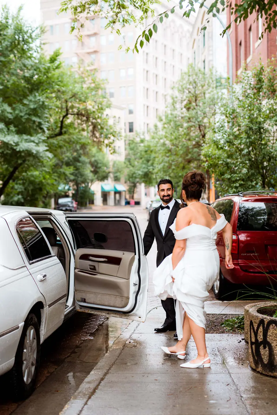 Wedding couple arriving by vintage car on a leafy Exchange District street