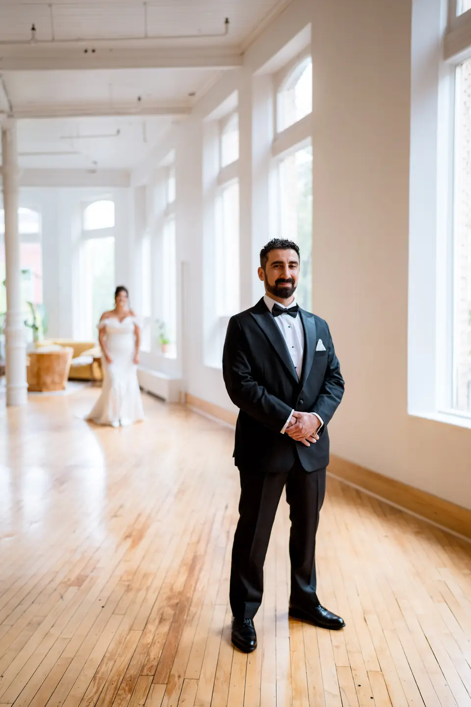 Groom waiting in the main hall as the bride walks toward him for the first look