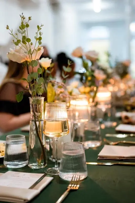Long dinner table with florals and candles set for an intimate reception