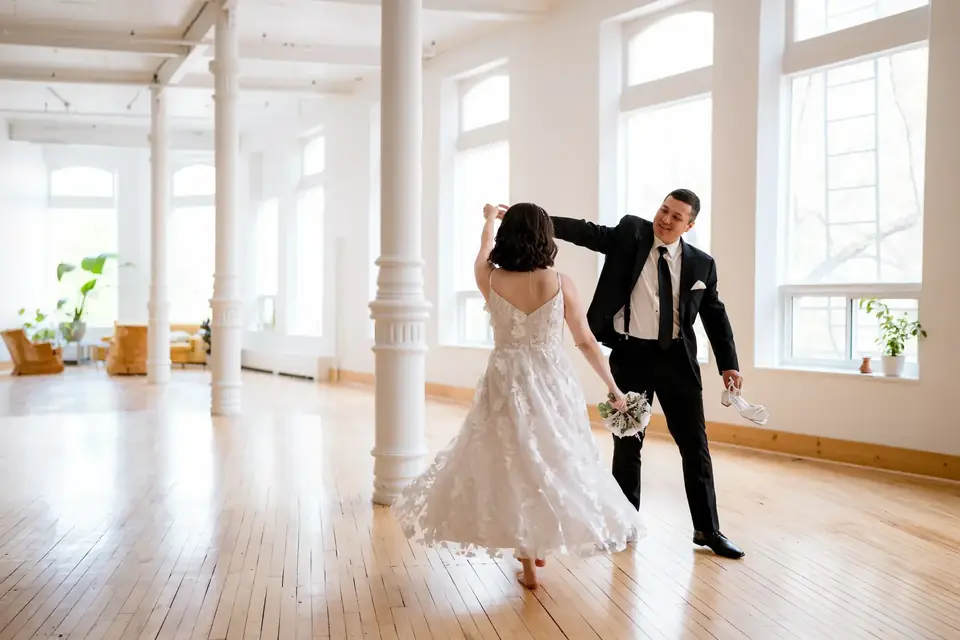 Couple sharing a first dance in the sunlit main hall